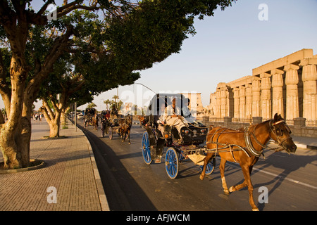 Ein Caleche oder bespannten Wagen macht seinen Weg vorbei Luxor-Tempel im Herzen der Stadt von Luxor, Ägypten Stockfoto