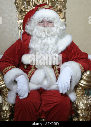 Weihnachtsmann sitzt auf seinem Thron in einer Grotte, die typisch für ein Einkaufszentrum Stockfoto