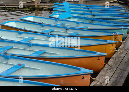 Mehrere kleine Ruderboote, Rümpfe malte Licht blau innen und etwas Orange außerhalb, zum Steg festgemacht. Stockfoto