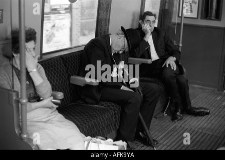 London Underground schlafender müder Geschäftsmann im Bowler Hut in der Londoner U-Bahn, die nach der Arbeit nach Hause fährt England 1970er Jahre HOMER SYKES Stockfoto