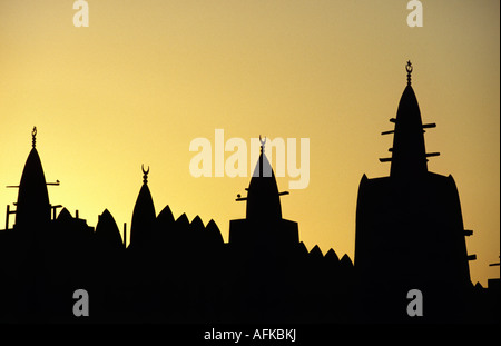 Die konischen Türmen der Grande Moschee von Mopti sind durch einen afrikanischen Sonnenuntergang Silhouette. Stockfoto