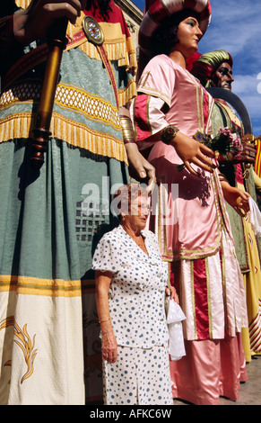 Eine Frau wird durch hoch aufragende Gegants (Riesen) als Teil Barcelonas Festival von La Merce Schatten gestellt. Stockfoto