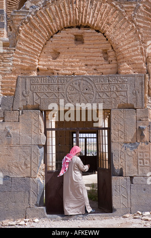 Ein Aufseher öffnet die zerstörte Byzantinische Kirche in Qasr ibn Wardan, Syrien, die bis ins 5. Jahrhundert zurückreicht. Stockfoto