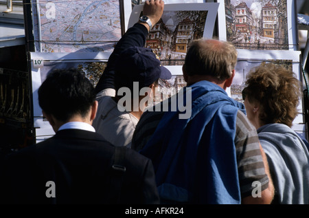 Gruppe von Touristen betrachten kaufen Aquarell Gemälde unter Straßenkunst, Montmartre, Paris, Frankreich. Stockfoto