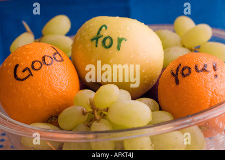 Obstschale voller Äpfel Orangen Trauben Stockfoto