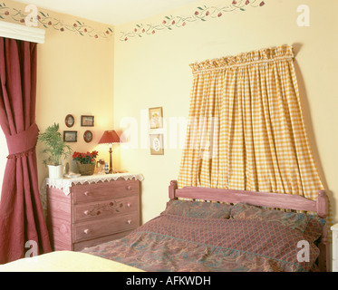 Gelbe Check Vorhang über rosa Bett in Anfang der neunziger Jahre mit rosa Kommode Schlafzimmer Stockfoto