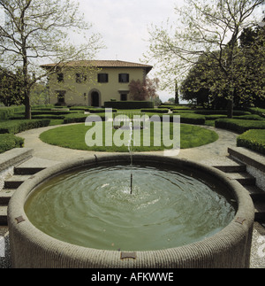 Brunnen in erhöhten kreisförmigen Pool in formalen italienischen Garten mit kreisförmigen Rasen und beschnittenen Sträuchern und Hecken Stockfoto