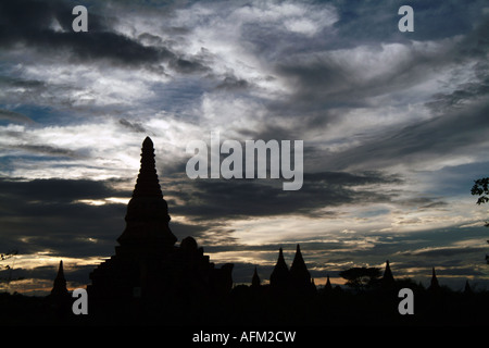 Die Sonne versinkt hinter einer Pagode in Bagan, Birma während des Monsuns. Stockfoto