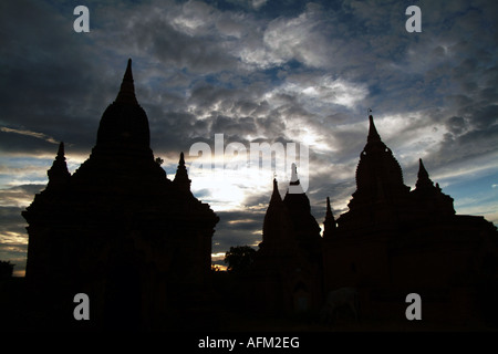 Die Sonne versinkt hinter einer Pagode in Bagan, Birma während des Monsuns. Stockfoto