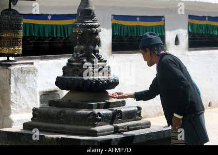 Ältere Frau, die eine Darbringung an die größte buddhistische Stupa der Welt in Kathmandu-Nepal Stockfoto