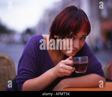 Schöne Holländerin Schlucke Tee in einem Café neben dem Kanal im Zentrum von Amsterdam. Stockfoto