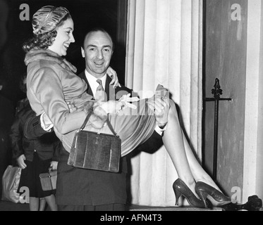 Profumo, John Dennis, 30.1.1915 - 10.3.2006, britischer Politiker, (konservativ), (Tories), halbe Länge, mit Frau Valerie Hobson, nach der Hochzeit, die eine Frau über der Schwelle trägt, Regent's Park, London, 31.12.1954, Stockfoto