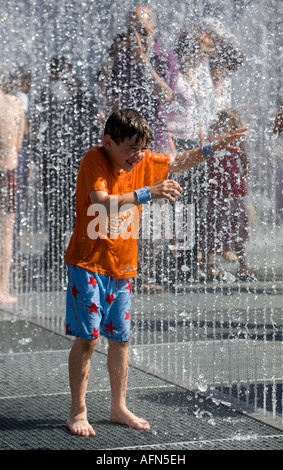 Kleiner Junge spielt im Brunnen vor der Royal Festival Hall auf der Londoner Themse Südbank Stockfoto