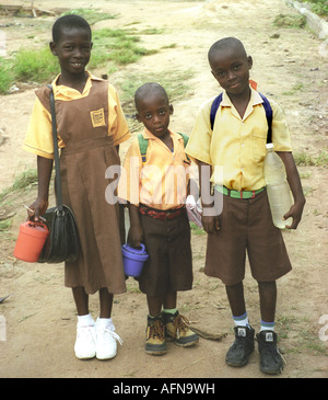 Drei kleine Kinder, ein Mädchen und zwei jungen in Schule Workwear-bereit zu gehen in die Grundschule im südlichen Ghana gekleidet Stockfoto