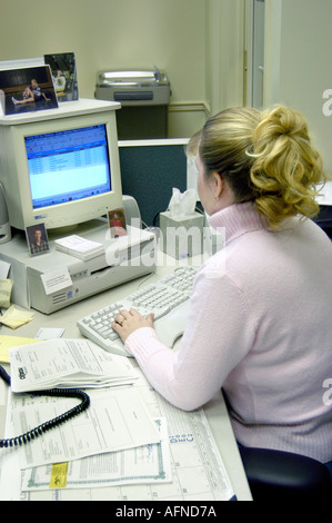Weibliche Angestellte an der Rezeption Arten Informationen in einen Kalender auf einem computer Stockfoto