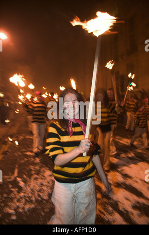 Weibliches Mitglied der kommerziellen Square Bonfire Gesellschaft trägt eine brennende Fackel während der jährlichen Feierlichkeiten Lewes Bonfire. Stockfoto