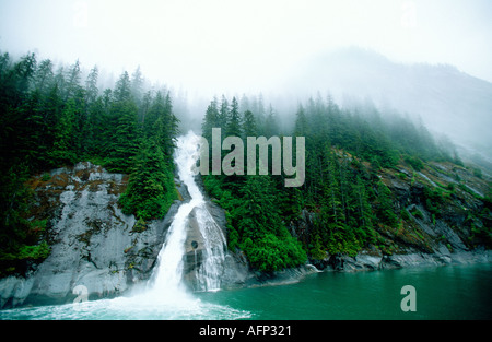 USA Southeast Alaska Tracie Arm Loch in der Wand Wasserfall Kaskadierung durch Earl Morgen Nebel und Berg-Hintergrund Stockfoto