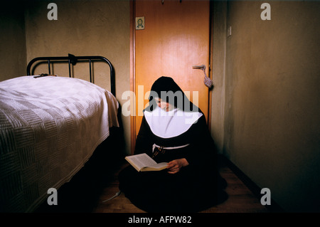 Junge Nonne UK. Schwester Colette in ihrer Zelle liest die bibel. Arme Clare Colettines sind ein katholischer geschlossener Orden Herefordshire 1989 1980er Jahre. HOMER SYKES Stockfoto