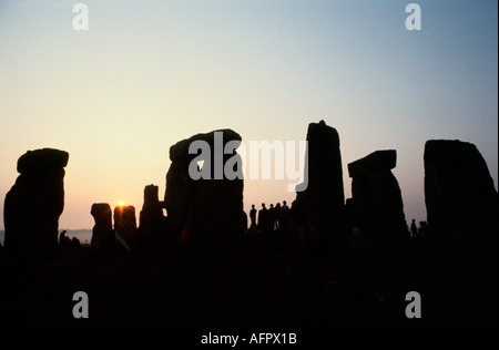 Stonehenge Silhouetten versammelten sich zur Sommersonnenwende in Großbritannien. Sie beobachten den Sonnenaufgang bei Sonnenaufgang am 21. Juni England, UK 1970s HOMER SYKES Stockfoto