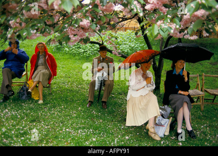 Schlechtwetter Sommerregen bei der Chelsea Flower Show London. Gruppe Leute, die Schirme oben halten, die unter einem Baum schützen 1980er Jahre 1984UK HOMER SYKES Stockfoto