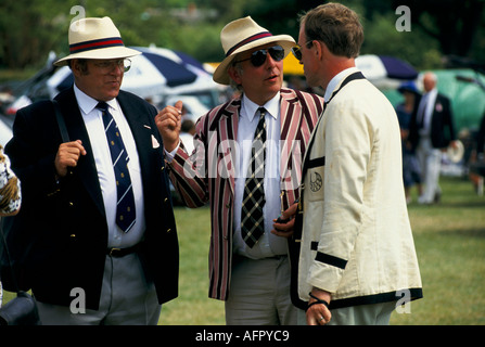 Männer mittleren Alters aus den 1980er Jahren sprechen, Freunde tragen Strohhüte und blaue Blazer in der Henley Royal Regatta. Henley on Thames Oxfordshire 1985 UK Stockfoto