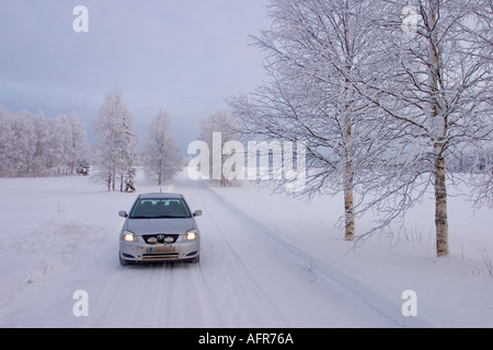 Toyota Corolla auf der verschneiten Landstraße in Winter, Finnland Stockfoto