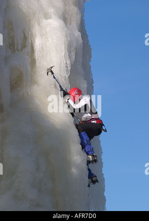 Eiskletterer Klettern auf Eiswand mit Achsen und Steigeisen, Finnland Stockfoto