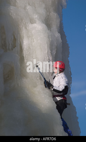 Eiskletterer Klettern auf Eiswand mit Achsen und Steigeisen, Finnland Stockfoto