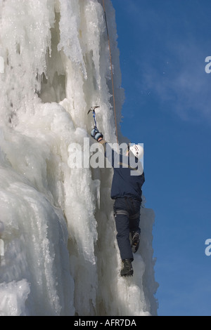 Eiskletterer Klettern auf Eiswand mit Eispickel und Steigeisen, Finnland Stockfoto