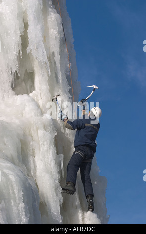 Eiskletterer Klettern auf Eiswand mit Eispickel und Steigeisen, Finnland Stockfoto