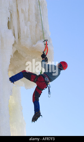 Eiskletterer klettern auf Eiswand mit Eispickel und Steigeisen versuchen, einen Überhang anzugehen, Finnland Stockfoto