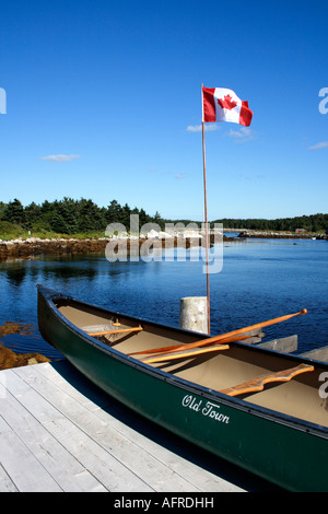 Old Town Kanu und kanadische Flagge auf Oceanside Pier, Nova Scotia, Kanada. Foto: Willy Matheisl Stockfoto