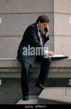 Mann Tun des Geschäfts auf sein Mobiltelefon. Stadt London England. Circa 1995 1990 s UK HOMER SYKES Stockfoto