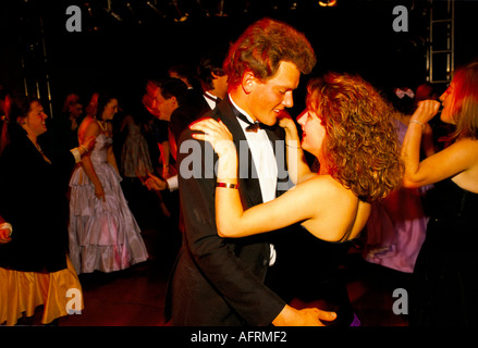 Das junge Paar aus den 1990er Jahren in Großbritannien, in formellem schwarzen Krawatte, Ballkleid tanzen die Nacht im Cirencester Royal Agricultural College Ende des Jahres Sommer Mai Ball Stockfoto