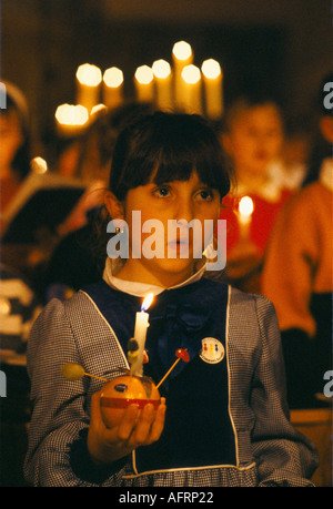 Teen schulmädchen. Christingle Weihnachtskirche Weihnachtsgottesdienst Chor singen. Halten angezündete Kerzen mit orangefarbenen Leighton Buzzard 1990er UK HOMER SYKES Stockfoto