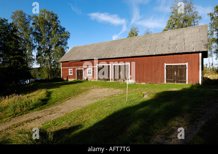 Alte schwedische Scheune in der typischen roten Farbe in der Morgensonne, Schweden Stockfoto