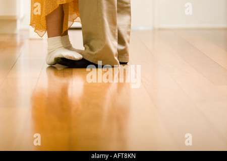 Tochter steht auf Vaters Füße, tanzen in Küche Stockfoto