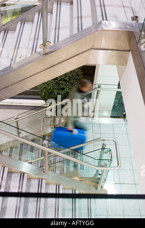 Mann am Flughafen beim Treppensteigen mit Koffer Stockfoto
