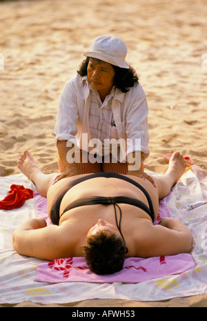 Übergewichtige Touristin wird am Strand massiert. Pattaya Thailand HOMER SYKES Stockfoto