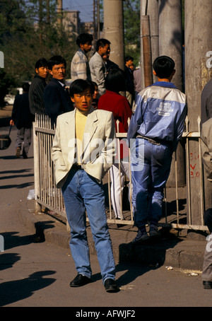 Peking China 1990er. Eine Gruppe klug gekleideter Arbeitsloser wartet auf einem inoffiziellen Job-Markt in der Nähe des Hauptbahnhofs 1998 HOMER SYKES Stockfoto