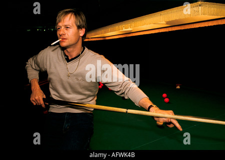 Alex Higgins Porträt der 1980er Jahre in den Übungsräumen, Preston Lancashire vor einem Turnier rauchend eine Zigarette Circa 1985 UK HOMER SYKES Stockfoto