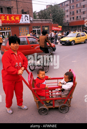 Peking China der 1990er Jahre. Chinesische Mutter und zwei Söhne, die einen Kinderwagen schieben, einen altmodischen Doppelwagen 1998 HOMER SYKES Stockfoto