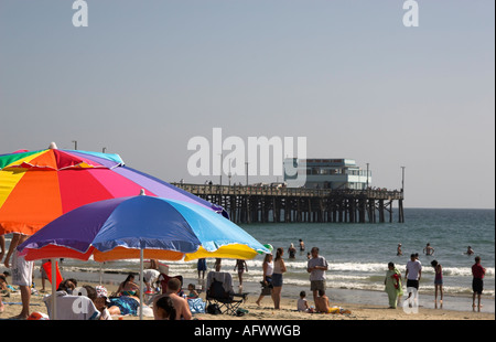 Bunten Regenschirm auf Balboa Beach, Newport Pier im Hintergrund, Newport Beach, Kalifornien, USA Stockfoto