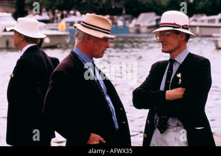Männer mittleren Alters der 1980er Jahre reden in Strohhüten blaue Blazer bei der Henley Royal Regatta. Henley on Thames Oxfordshire 1985 UK HOMER SYKES Stockfoto