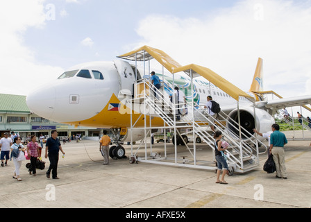 Passagiere, die zu Fuß auf Asphalt und Boarding Cebu Pacific Flugzeug Philippinen Tagbilaran Flughafen Bohol Visayas Stockfoto