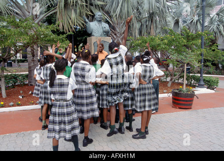 Schüler und Lehrer vor Büste von Sir Milo Butler in Rawson Square Nassau Bahamas Stockfoto