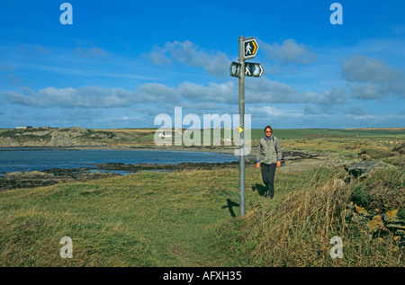 ABERFFRAW ANGLESEY NORTH WALES UK September Frau zu Fuß entlang der Isle of Anglesey Küste in Porth Cwyfan Stockfoto