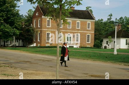 COLONIAL WILLIAMSBURG VIRGINIA USA August One der kostümierten Interpreten vorbei an einem 18thc Haus am Marktplatz Stockfoto