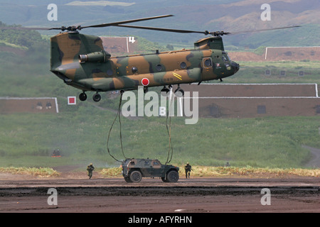 Boeing CH-47 Chinook Hubschrauber von Japan Boden Self Defence Force anheben ein Fahrzeug Stockfoto