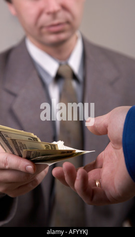 Geschäftsmann im Anzug Dollar zu anderen Mann geben Stockfoto